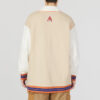 Chaqueta con cuello en V y escudo del equipo en beige